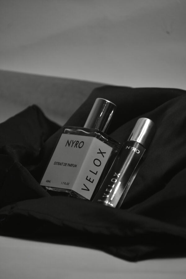 Nyro Velox Perfume Bottles on Black Silk with Elegant Packaging for a Luxurious Fragrance Experience