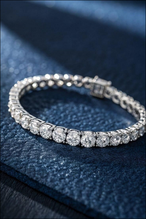 Silver tennis bracelet featuring large, round sparkling diamonds on a navy blue textured background.