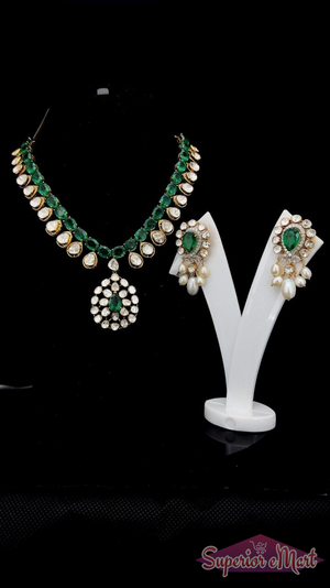 Gold-toned emerald and white stone jewelry set with a floral pendant and matching pearl drop earrings.