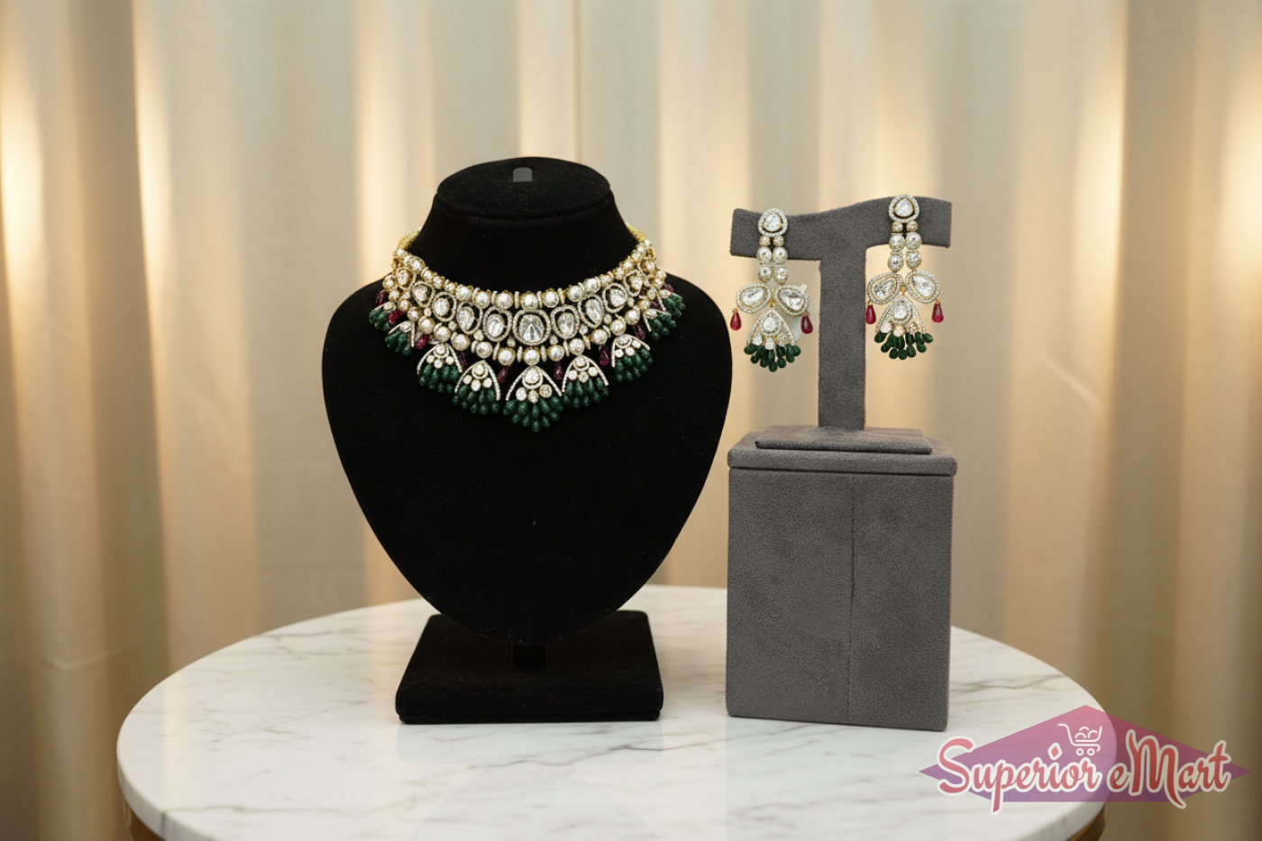 Ornate gold necklace and earring set with diamonds, green emerald beads, and red rubies on velvet display stands.