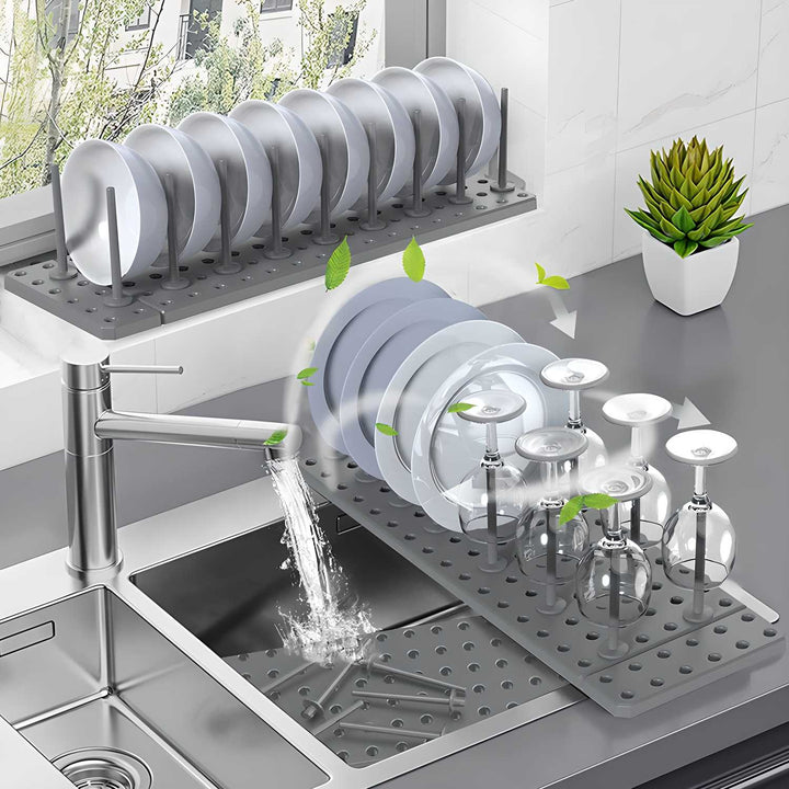 Adjustable pegboard dish rack holding plates and glasses on a kitchen countertop near a sink