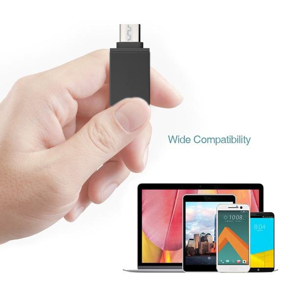 USB-C OTG adapter held in hand with various compatible devices in the background