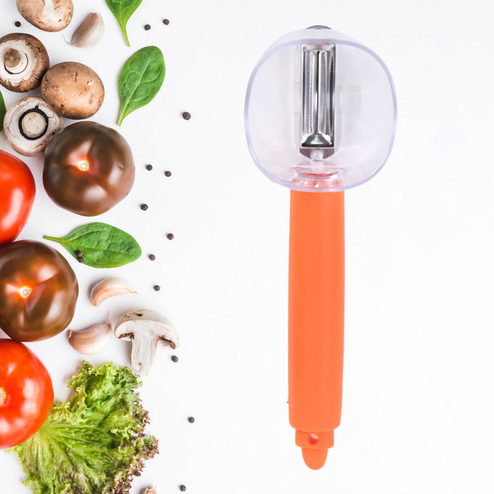 Superior eMart vegetable peeler with container and orange handle next to fresh vegetables