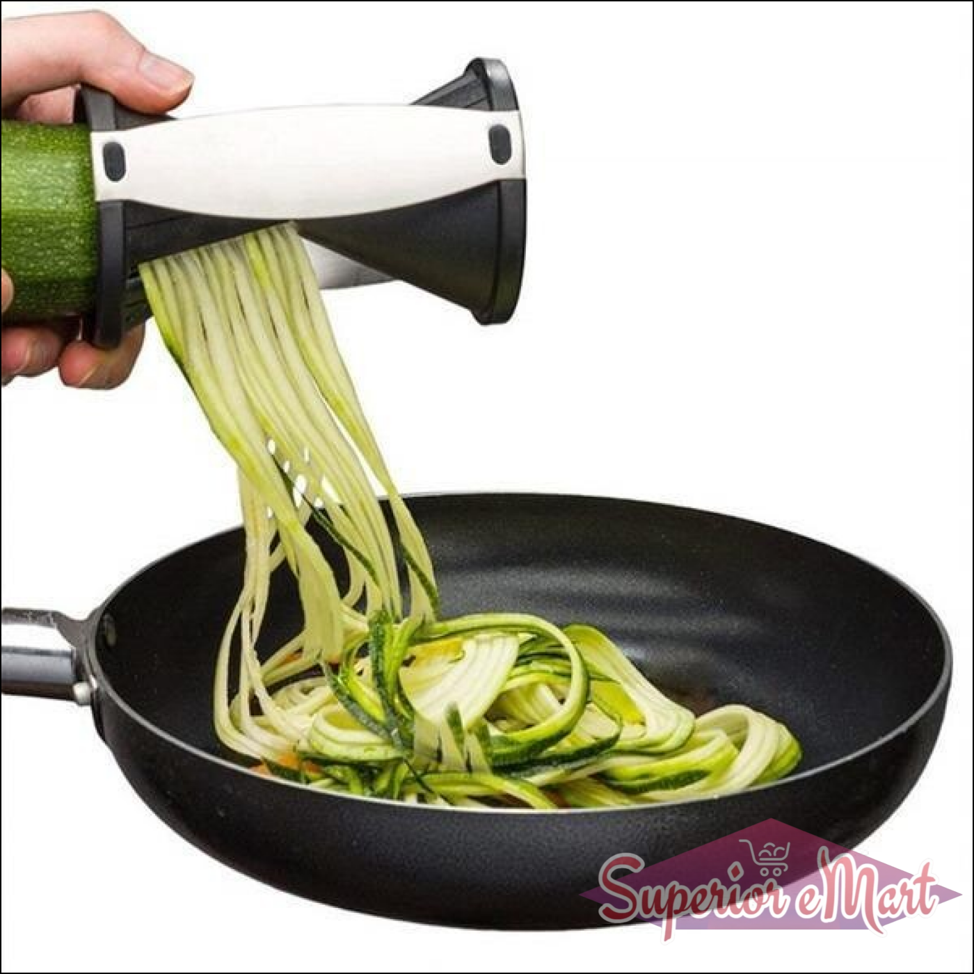 Handheld vegetable spiralizer slicer creating zucchini noodles in a frying pan