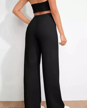 Person wearing black high-waisted pants on a plain background