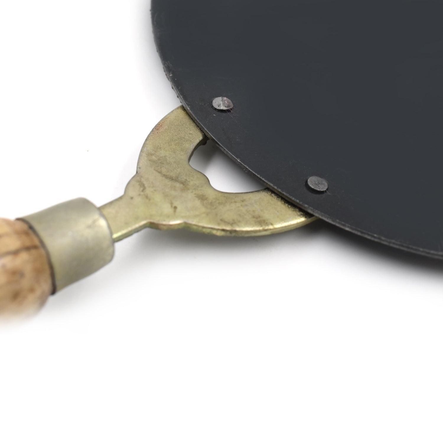 Close-up of wooden handle roti tawa with metal base for perfect cooking and even heat distribution